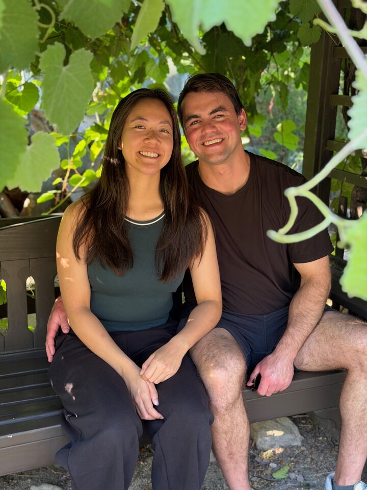 Ian and Kaitlyn sitting together under grape vines, Newport Beach